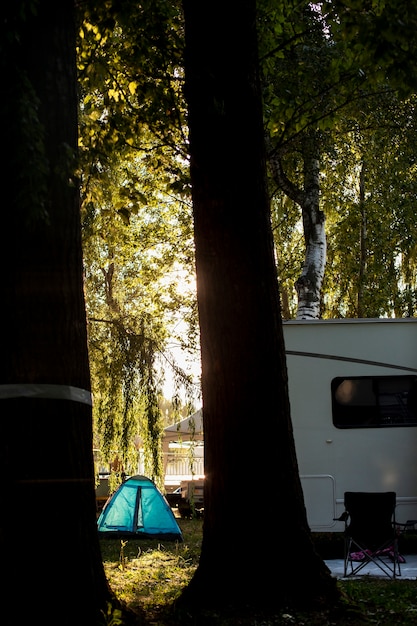 캠핑 숲에서 흰색 밴과 파란색 텐트