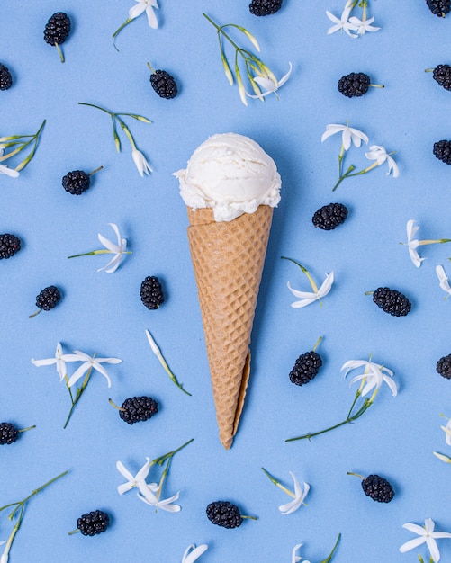 Free photo white vanilla ice cream surrounded by blackberries and flowers