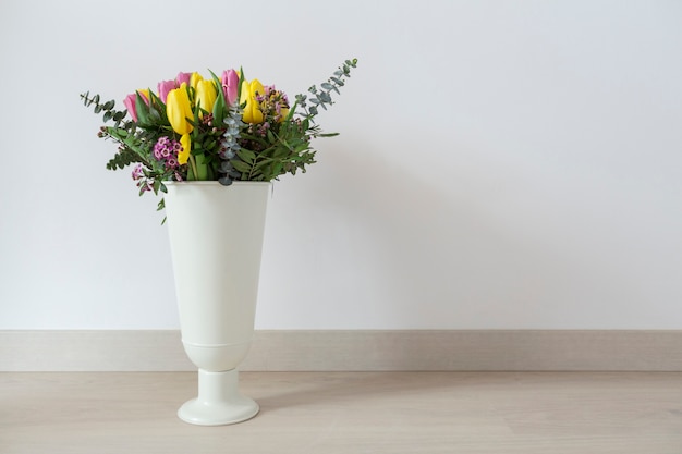 White vase with colored tulips