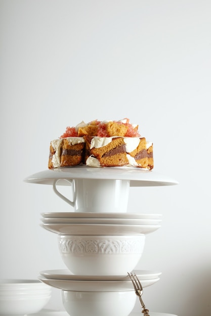 Бесплатное фото Белая винтажная чайная посуда и серебряная десертная ложка с нетрадиционным свадебным тортом с шоколадом, сливками и фруктами на вершине