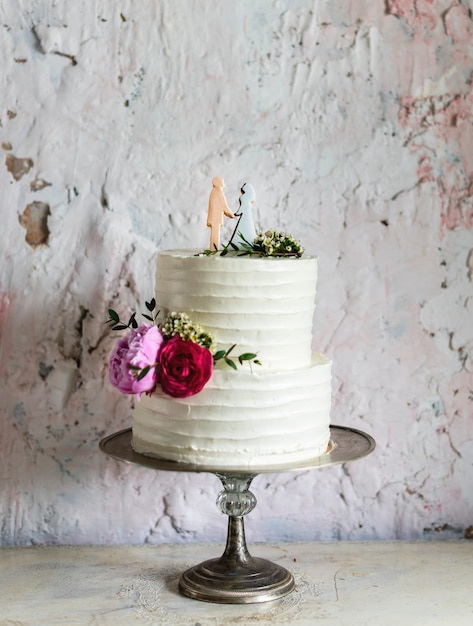 Foto gratuita topper per torta nuziale bianca con figura di sposi e sposo