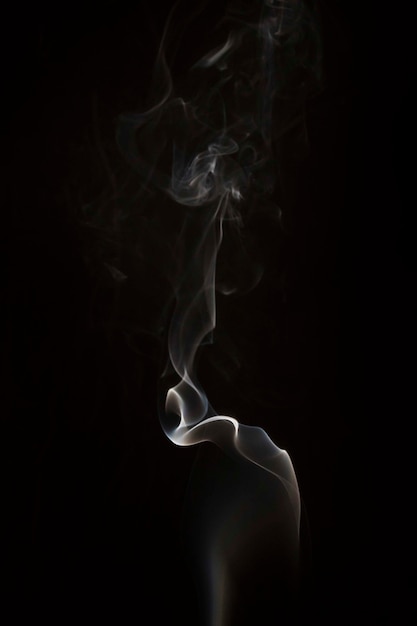 Бесплатное фото Белые тонкие клубы дыма на черном фоне