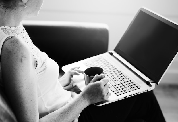 Foto gratuita donna bianca che usa il laptop sul divano