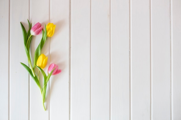 Белая деревянная поверхность с красивыми тюльпанами