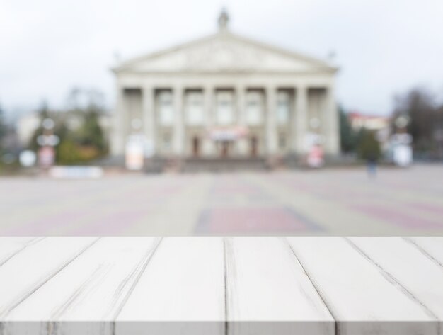 White wooden table in front of blurred classical public building fa�ade