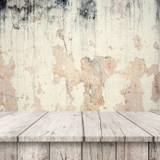 White wooden tables with a very damaged wall