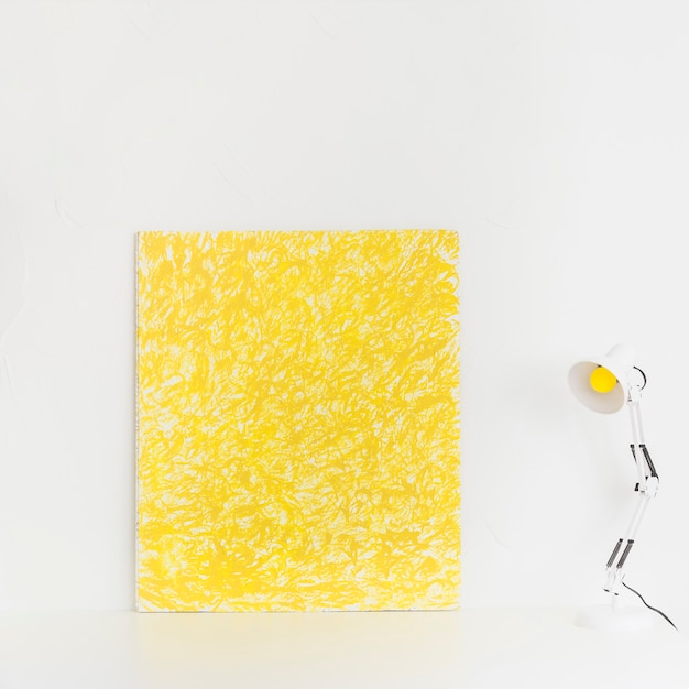 White workspace with yellow picture and reading lamp