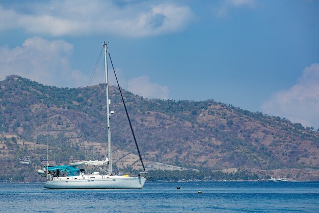 White yacht with mountains. 