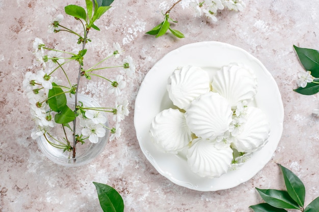 Free photo white zephyr,delicious marshmallows with spring blossom flowers