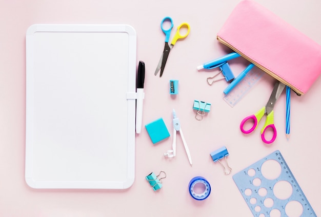 Whiteboard with marker and stationery items 