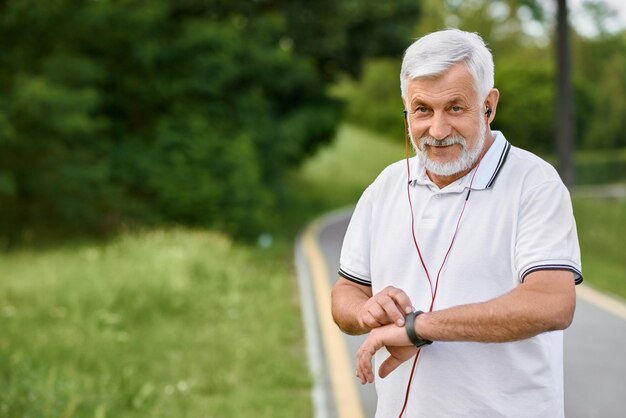 Whitehaired sportsman looking at camera on city's racetrack