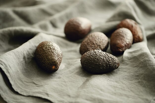 Free photo whole avocados on grey cloth