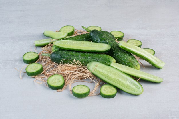 Whole and chopped cucumbers on stone surface. High quality photo