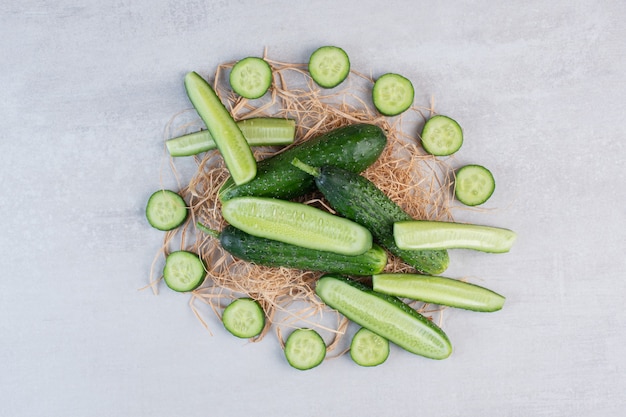 Whole and chopped cucumbers on stone surface. High quality photo