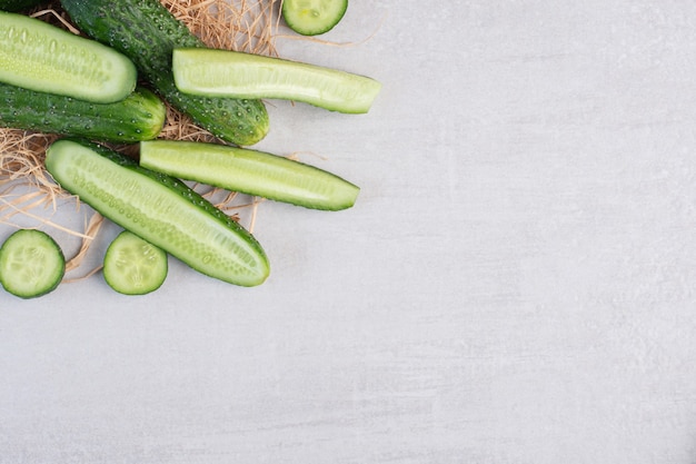 Whole and chopped cucumbers on stone surface. High quality photo