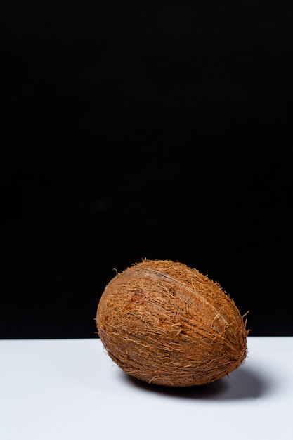 Whole coconut on a table on a black