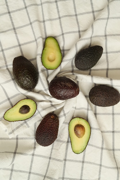 Whole and cut avocados on dishcloth