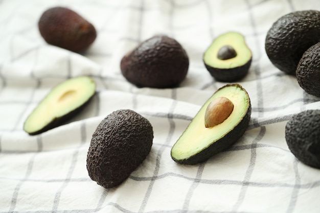 Whole and cut avocados on dishcloth