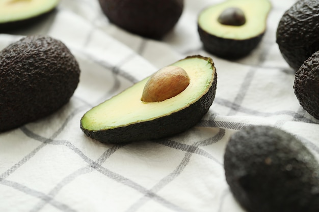 Whole and cut avocados on dishcloth