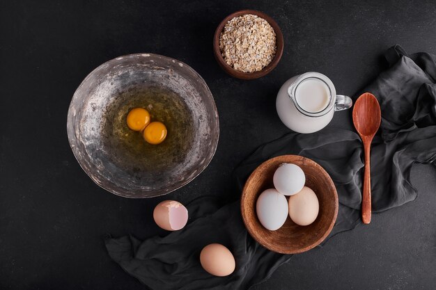 Whole eggs and yolks in wooden and metallic plates. 