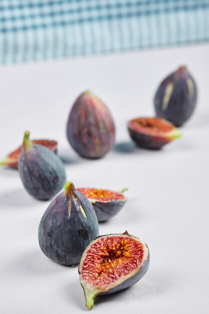 Whole fig and fig slices on white.