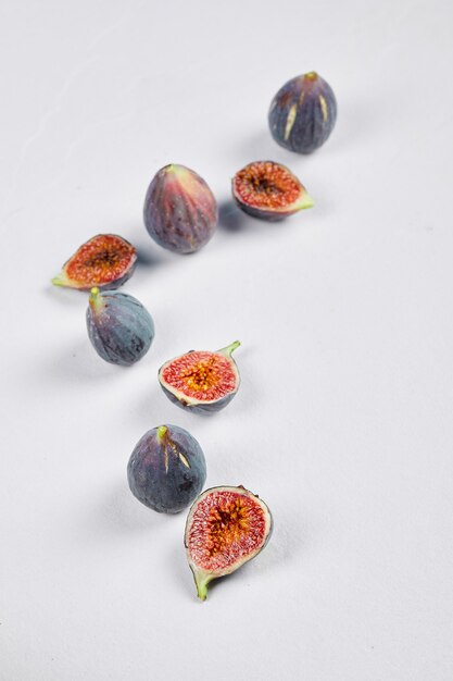 Whole fig and fig slices on white.