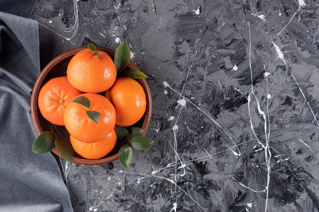 잎이 나무 그릇에 배치 된 전체 신선한 오렌지 과일