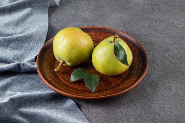 Free photo whole green pears placed on a stone table.