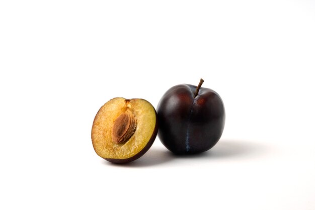 Whole and half cut black cherry plum