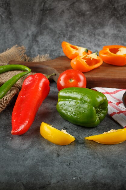 Whole and half cut fresh bell peppers .