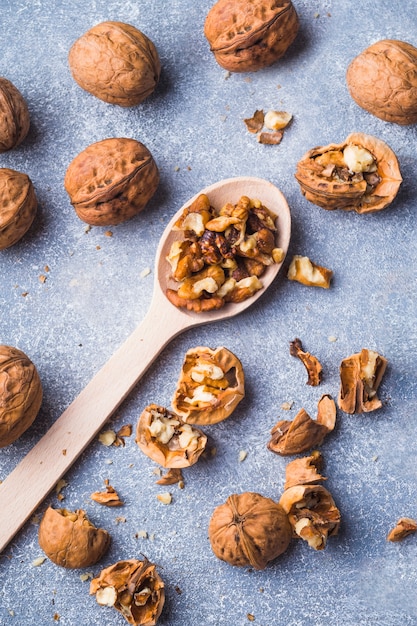 Whole and kernel walnuts on rough textured backdrop