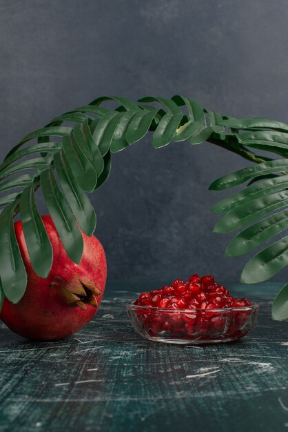 Whole pomegranate and seeds on marble table