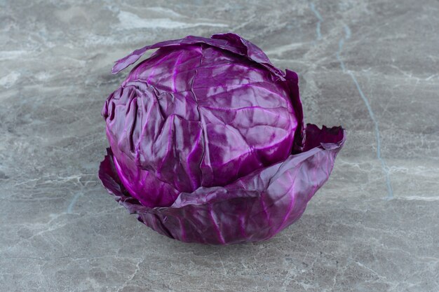 Whole purple cabbage , on the marble table. 
