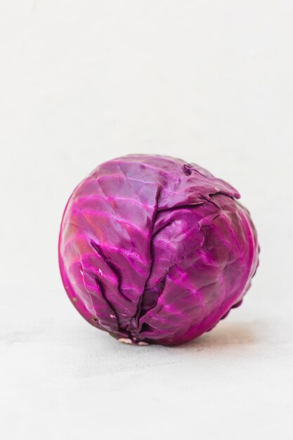 Whole red cabbage against white background