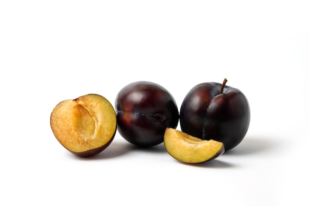 Whole and sliced black cherry plums