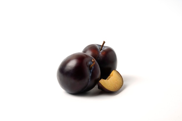 Whole and sliced black cherry plums