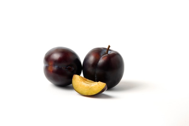 Free photo whole and sliced black cherry plums