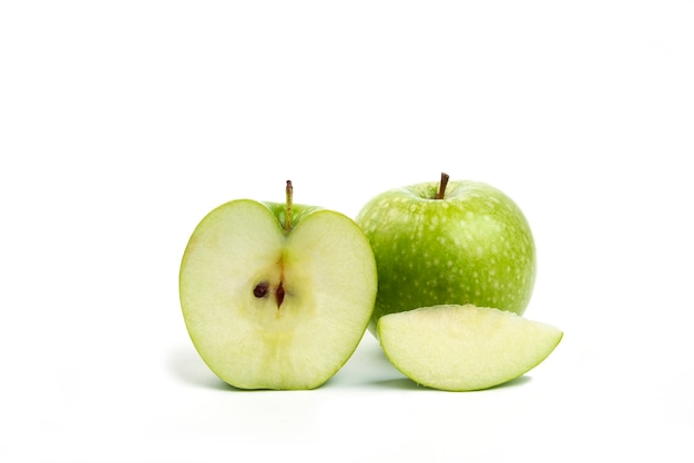 Whole and sliced green apples isolated on white.