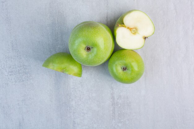 Whole and sliced green tasty apple , on the marble.