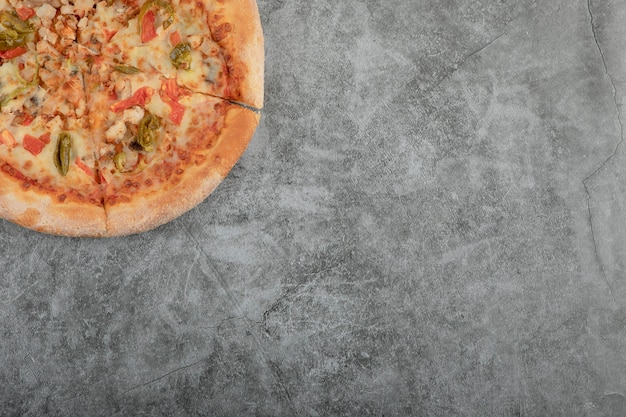 Free photo whole tasty chicken pizza placed on stone background.