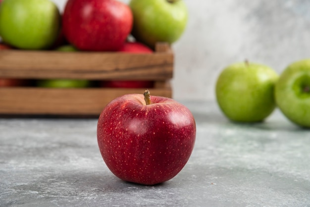 Free photo whole wet green and red apples on wooden cutting board.