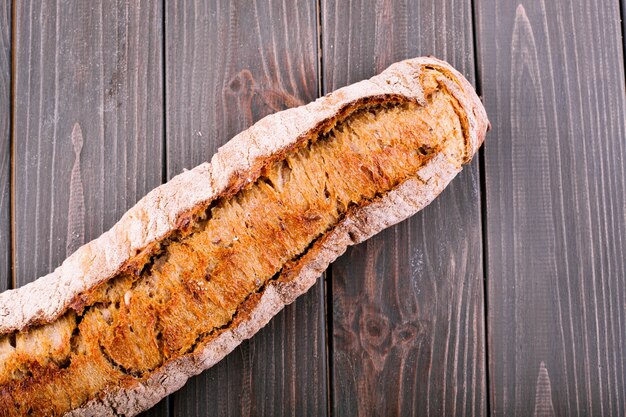 Wholemeal bread lies on dark wooden table