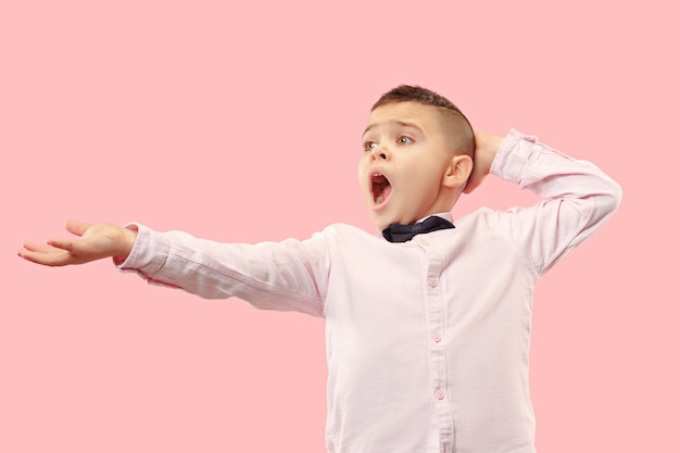 Free photo why is that. beautiful male half-length portrait isolated on trendy pink studio backgroud. young emotional surprised, frustrated and bewildered teen boy. human emotions, facial expression concept.