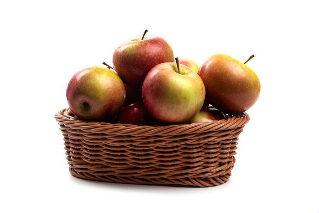 Wicker basket of fresh juicy apples isolated on white.