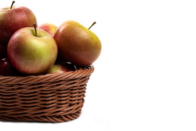 Wicker basket of fresh juicy apples isolated on white.