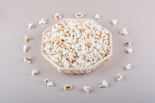 Wicker basket of salted popcorn for movie night on white background. High quality photo