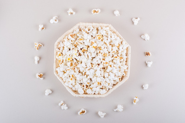 Wicker basket of salted popcorn for movie night on white background. High quality photo