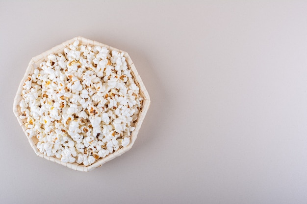Wicker basket of salted popcorn for movie night on white background. High quality photo