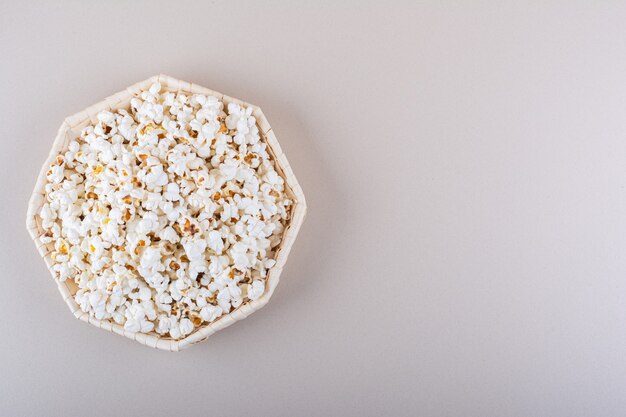 Плетеная корзина соленого попкорна для ночи кино на белом фоне. Фото высокого качества