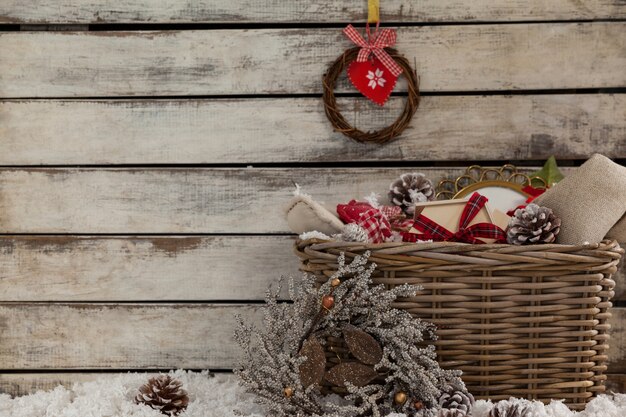 Плетеная корзина с рождественские украшения и искусственный снег